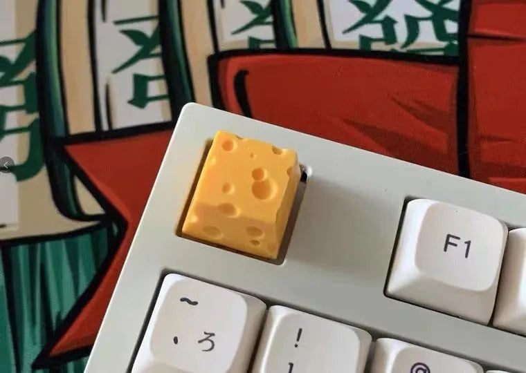 Yellow resin artisan keycap with a three-dimensional cheese design for mechanical keyboards.