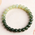 Natural Hetian jade bracelet with clear water gradient colour on wrist, showing polished beads.