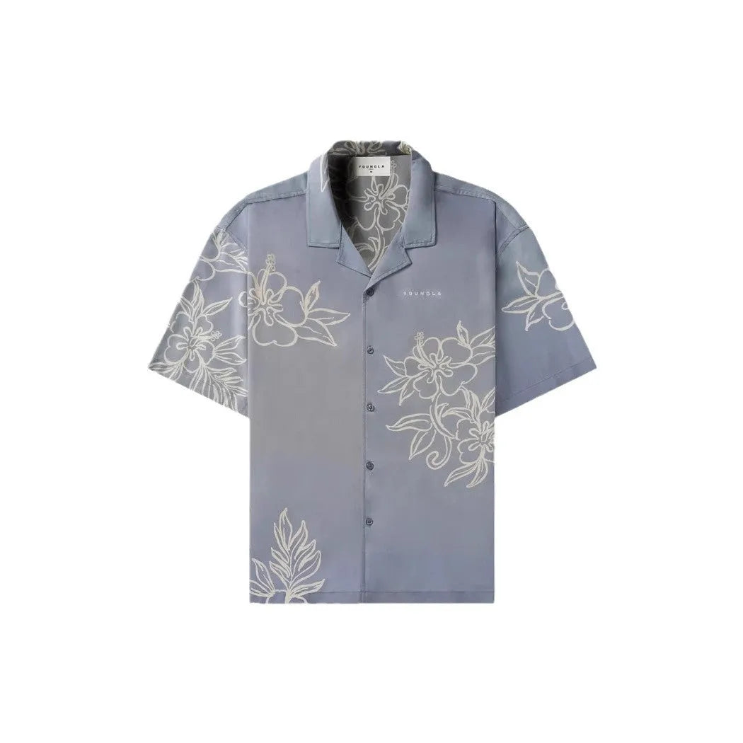 Man wearing a loose-fitting grey short-sleeve top with a floral print design.