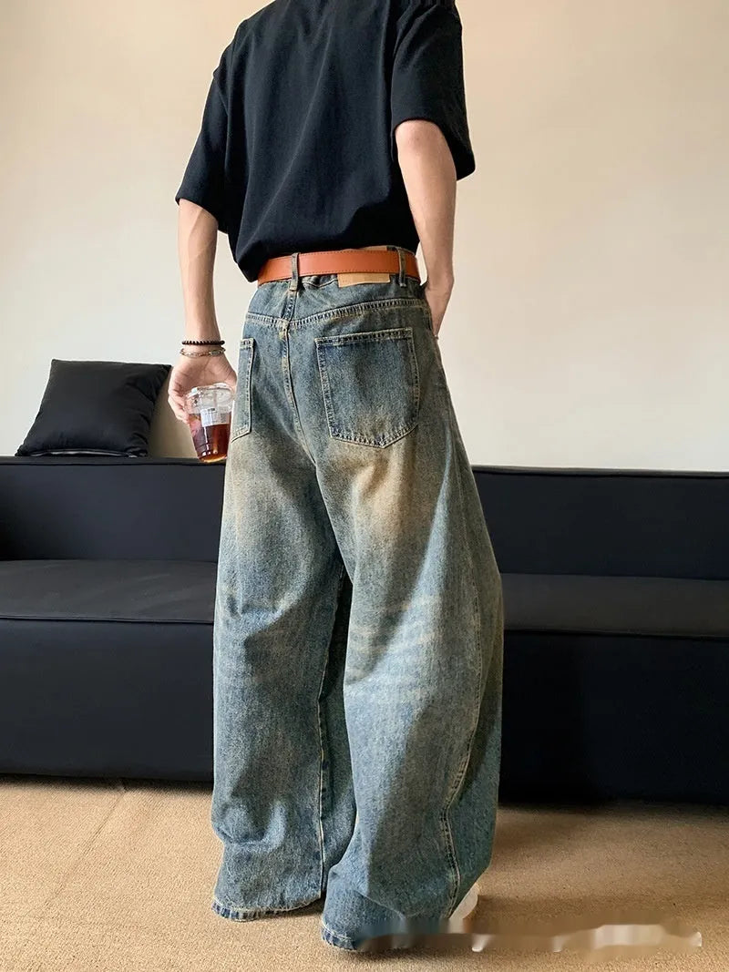 Men's retro blue distressed denim jeans with a slimming wide-leg fit and machete wash detail.