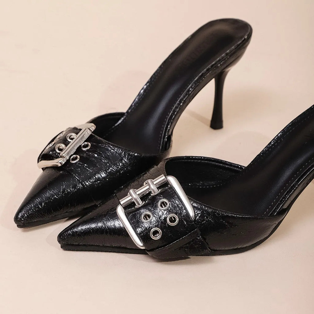 Black women's high heels with pointed toe and ankle strap featuring a decorative buckle.