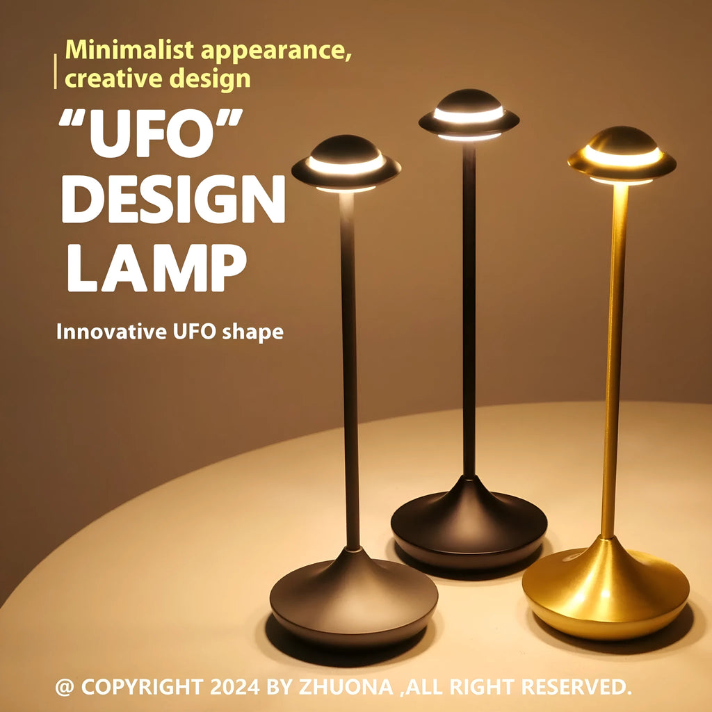 Metallic UFO-shaped rechargeable table lamp with touch controls in black finish on a wooden desk.