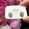 A pair of square, geometric diamond-treated alloy earrings in a gold colour on a white background.