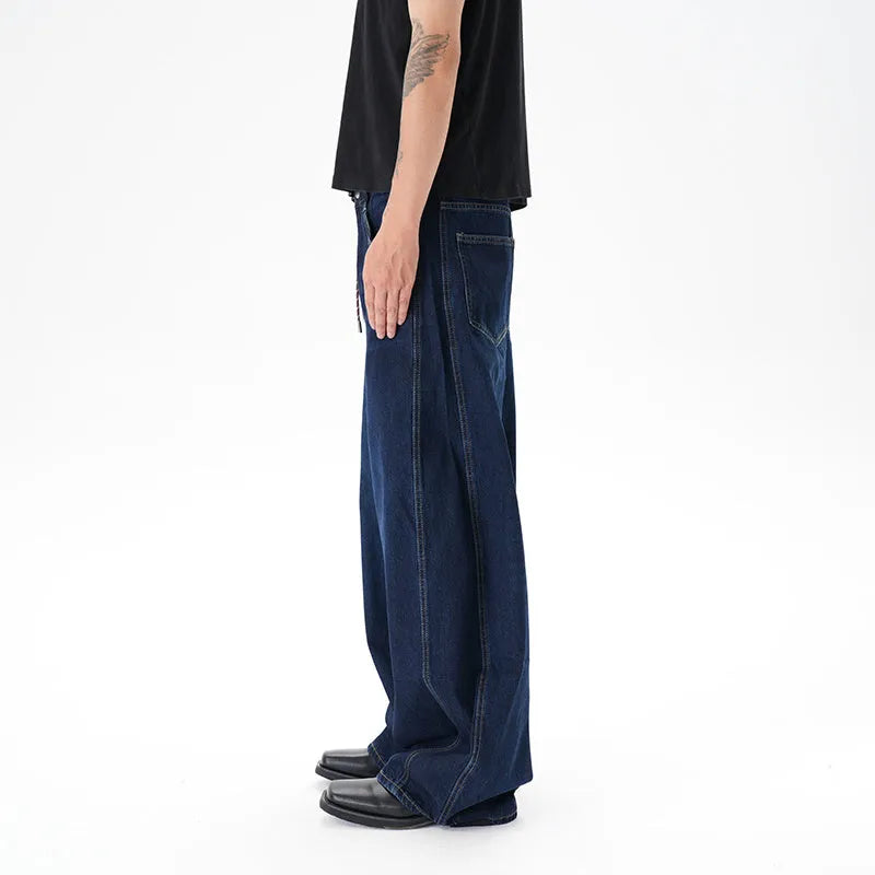 Dark blue washed distressed wide leg machete jeans showing fading and whiskering details