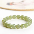 Polished Hetian jade beaded bracelet on a wrist, showing ice-like clear colour tones and spherical beads.