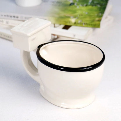 Humorous toilet-shaped ceramic coffee mug with handgrip, perfect for gag gifts or unique decor