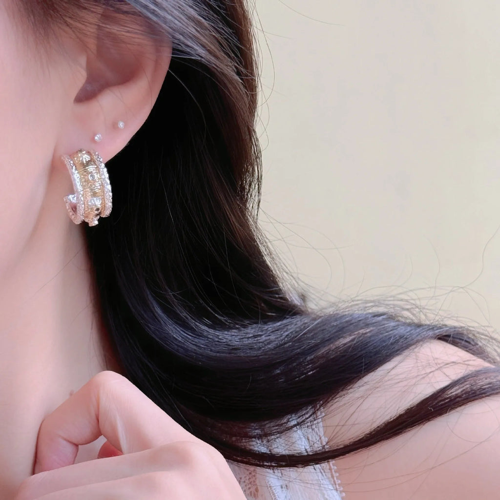 Gold and silver colour matching C-shaped brushed ring earrings with 925 silver needle on display