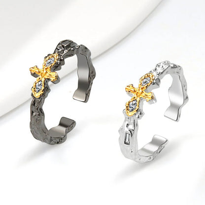 Dark Maillard Ring with geometric cross design in black gold and silver, adjustable for a perfect fit.