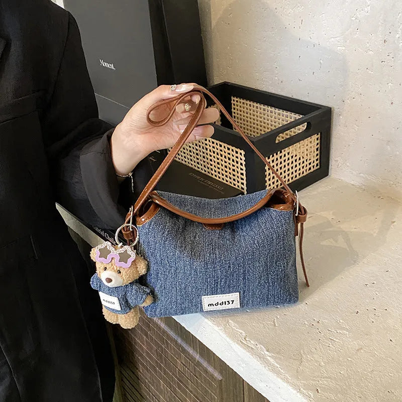 Denim small crossbody bag in black with slit pocket, horizontal square shape, medium hardness, polyester lining.