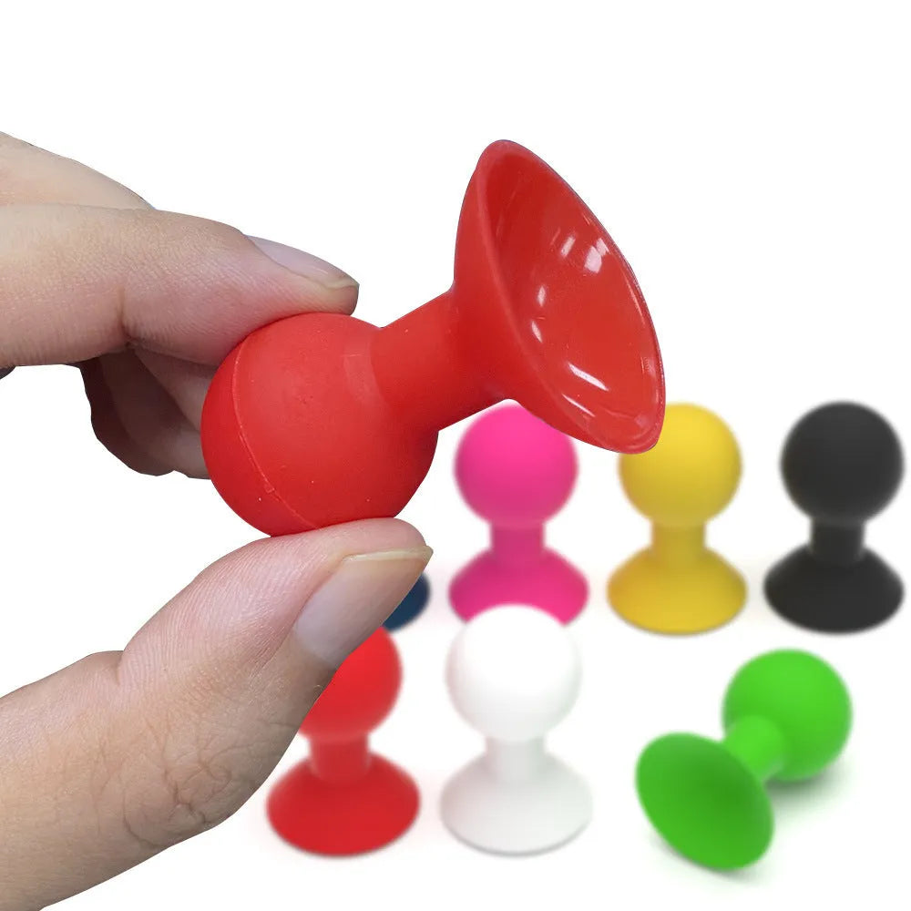 Silicone octopus ball mobile phone holder in blue holding a smartphone on a desk