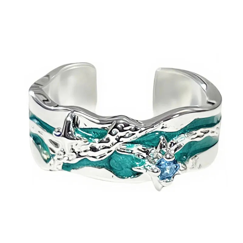 Mint green enamel eight-point asterism ring on a copper base, showing asymmetric and folded design details.