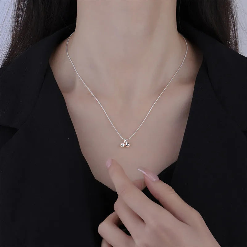 Silver cherry pendant necklace on an adjustable snake bone chain for women.