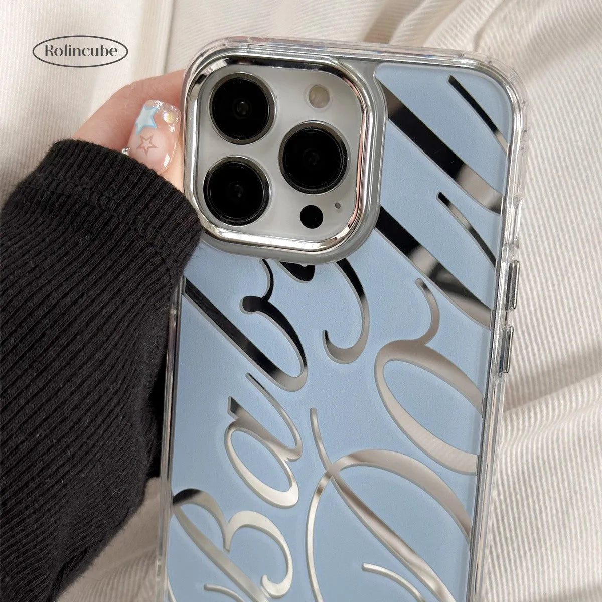 Blue transparent iPhone case with a mirror back panel showing JMKJ English lettering.