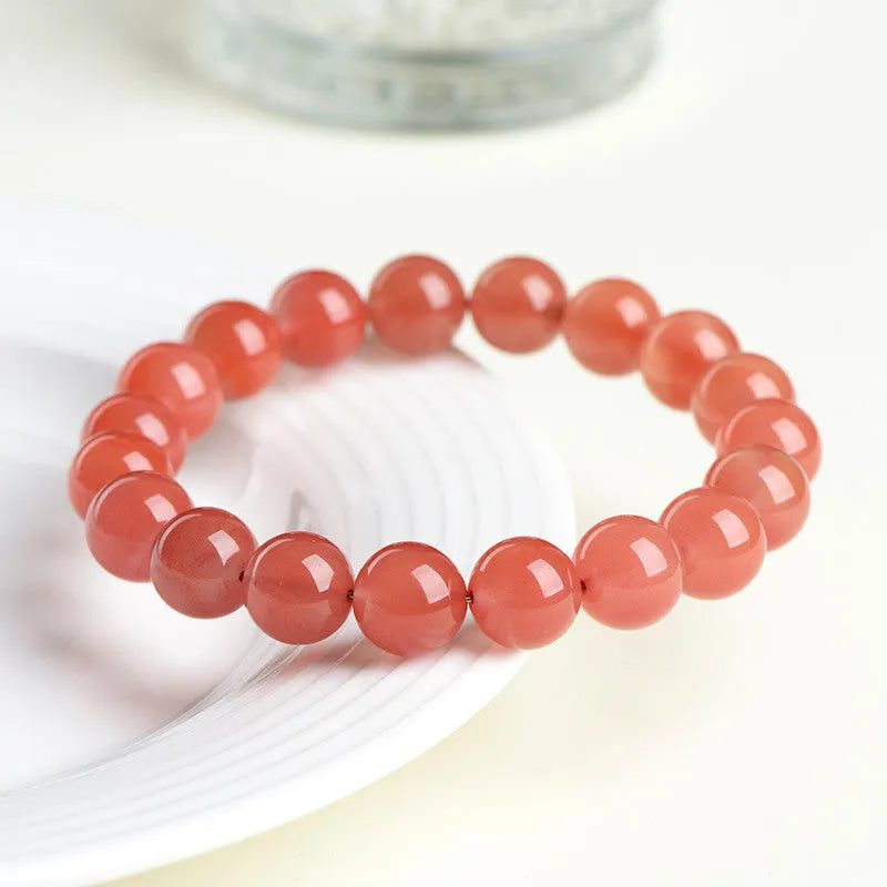 Natural South Red Cherry Agate bracelet on a wrist, showing polished beads in a single strand design.