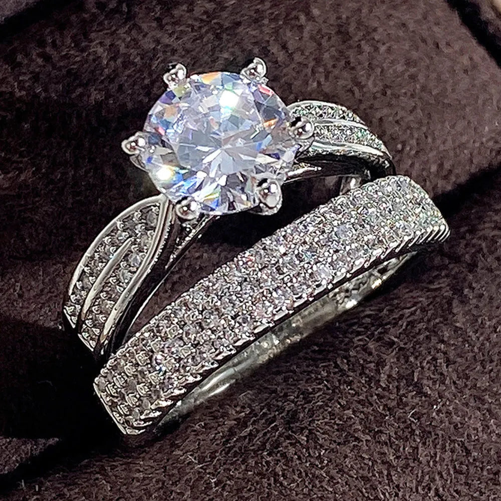 Geometric white gold colour alloy wedding ring on a finger, showing its round design.