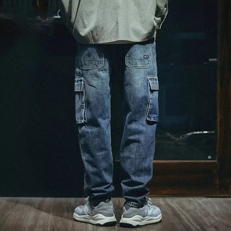 Men's blue loose straight leg jeans with a zip fly on a plain background.