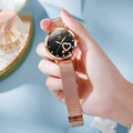 Women's rose gold alloy watch with a mesh strap, showing white, black, blue, red, pink, and green dial colour options.