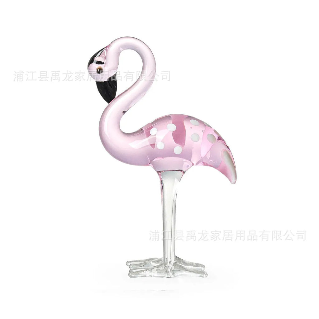 A pink flamingo decorative ornament made from clear white crystal on a table.