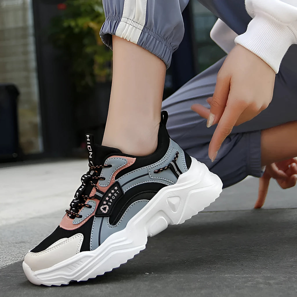 White women's casual sneaker with mesh upper, thick PU sole, buckle detail, and round toe.