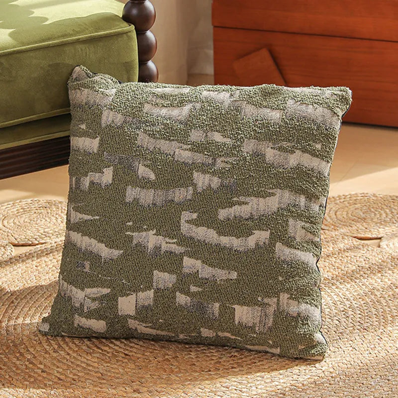 Square jacquard cushion cover with a detailed woven botanical pattern in a retro colour, shown on a grey sofa.