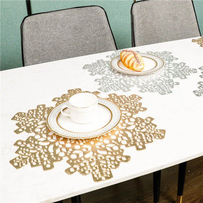 Stylish snowflake-patterned placemats in gold and silver, designed for heat resistance and spill protection on dining tables