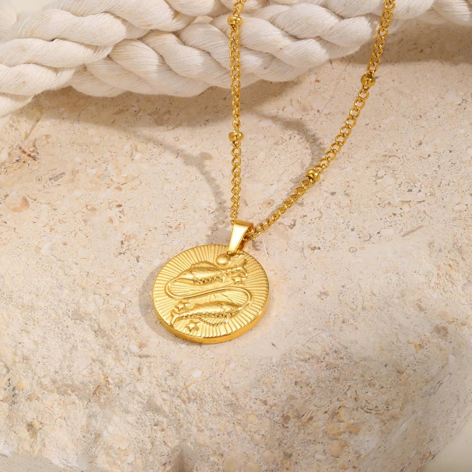 Silver stainless steel zodiac necklace with geometric round pendant showing embossed constellation design