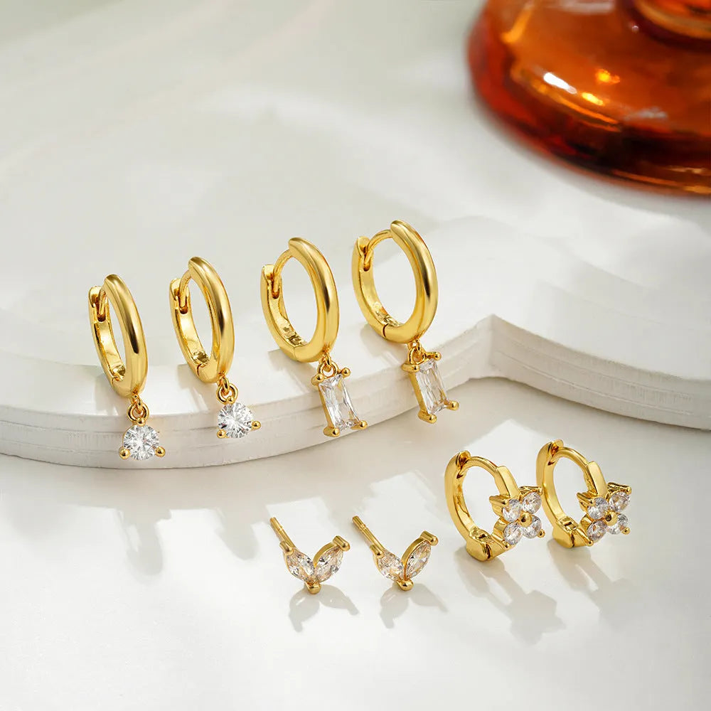 Four-piece set of geometric copper earrings with gold or silver plating, showing star and square shapes.