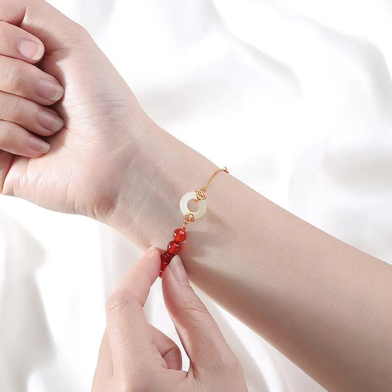 Close-up of a women's sterling silver bracelet with a peace buckle and engraved Chinese cloud and character motifs.