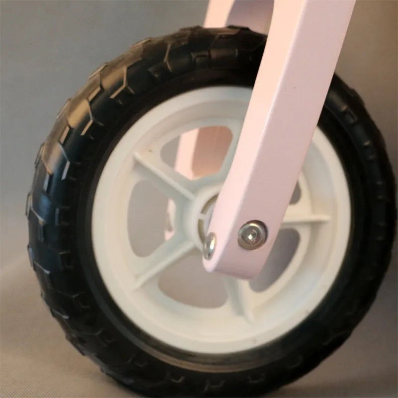Pink wooden balance scooter for toddlers on a 10-inch wooden deck.
