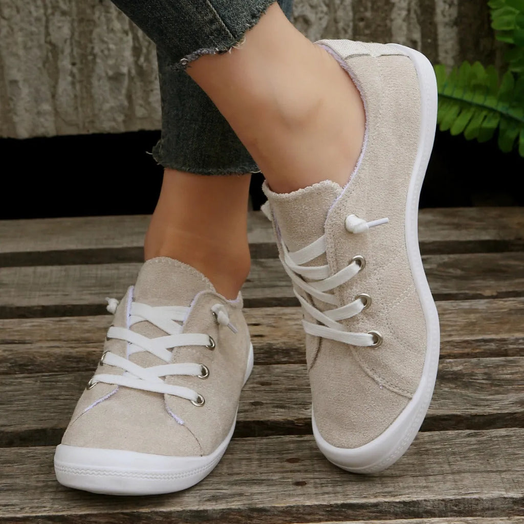 Women's creamy white low-top fabric sneakers with a casual rubber sole on a neutral background