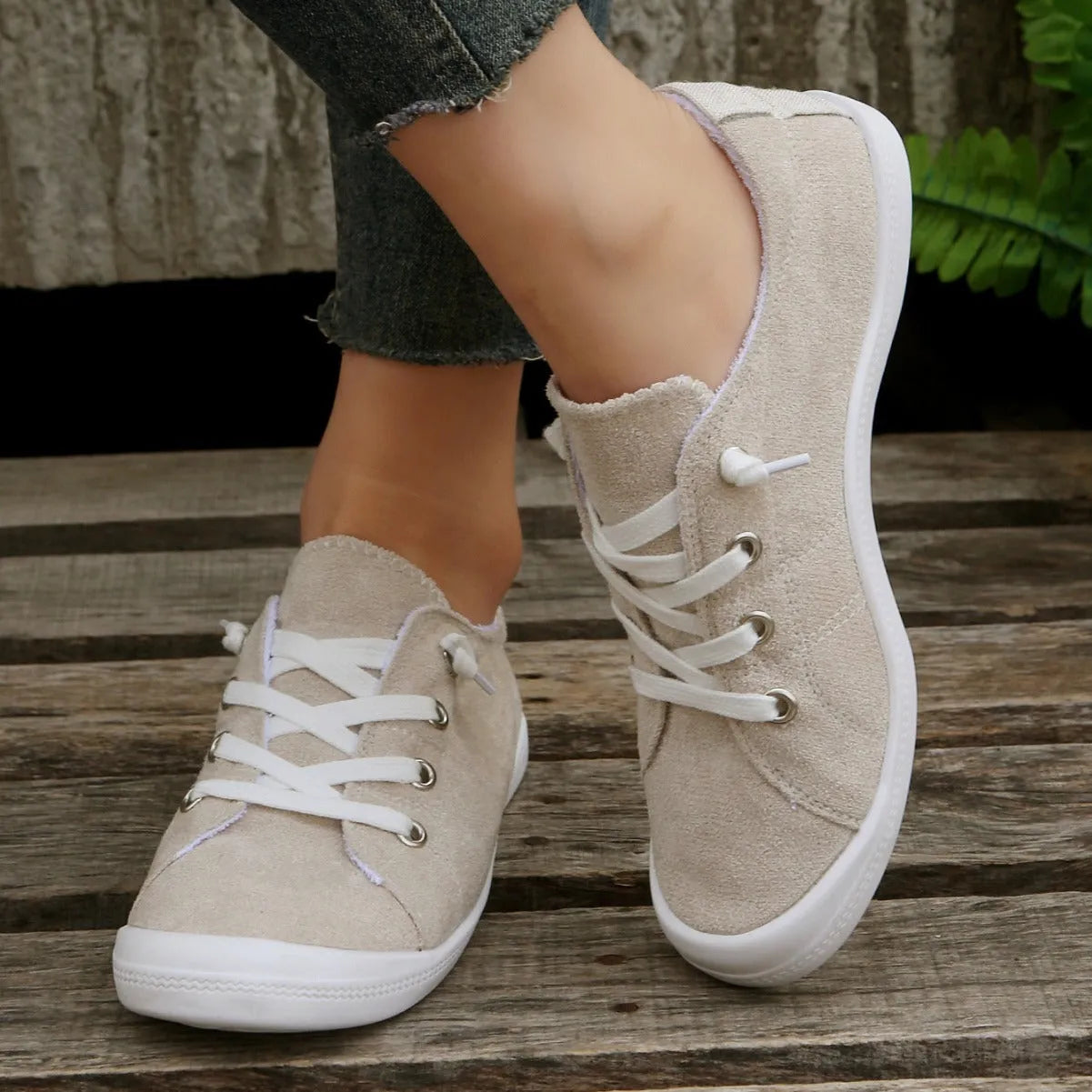 Women's creamy white low-top fabric sneakers with a casual rubber sole on a neutral background