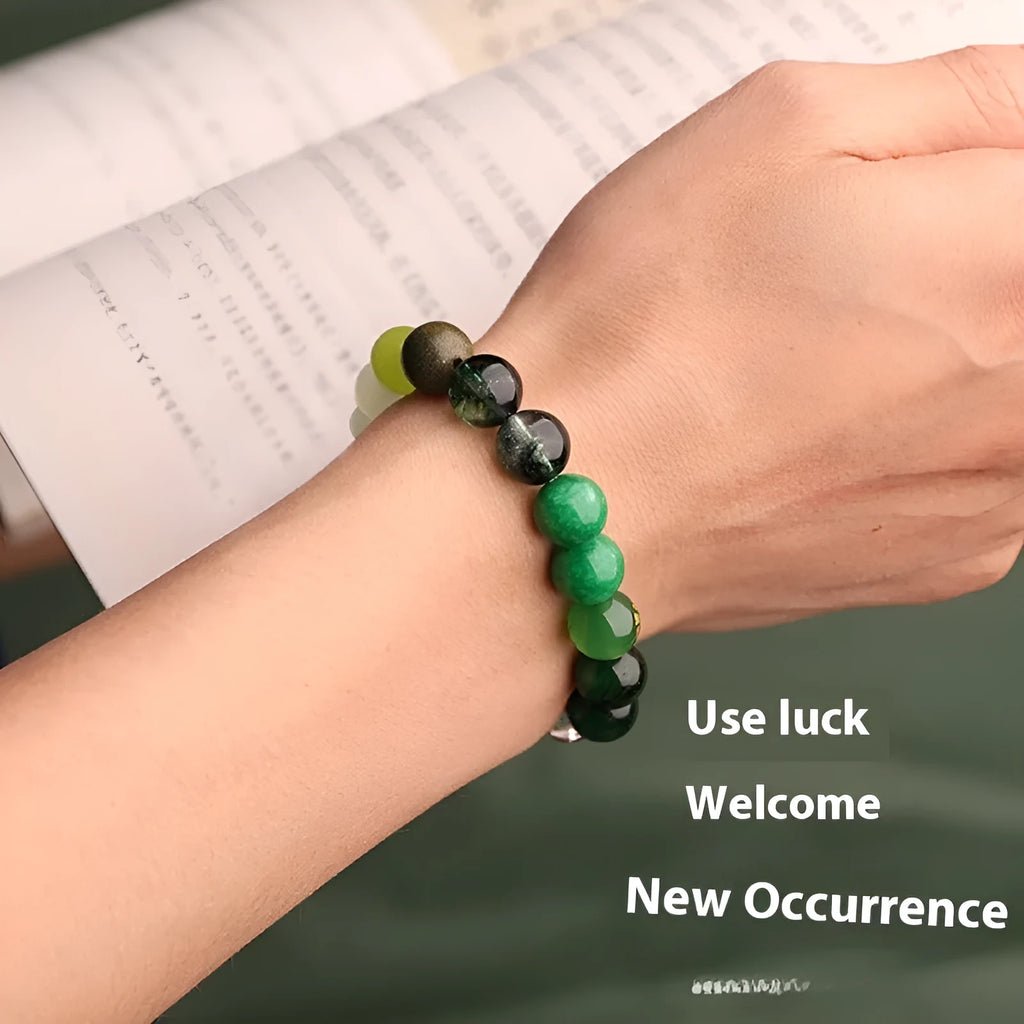 A polished agate energy bracelet showing natural stone beads in one of five colours, with decorative auspicious symbol charms.