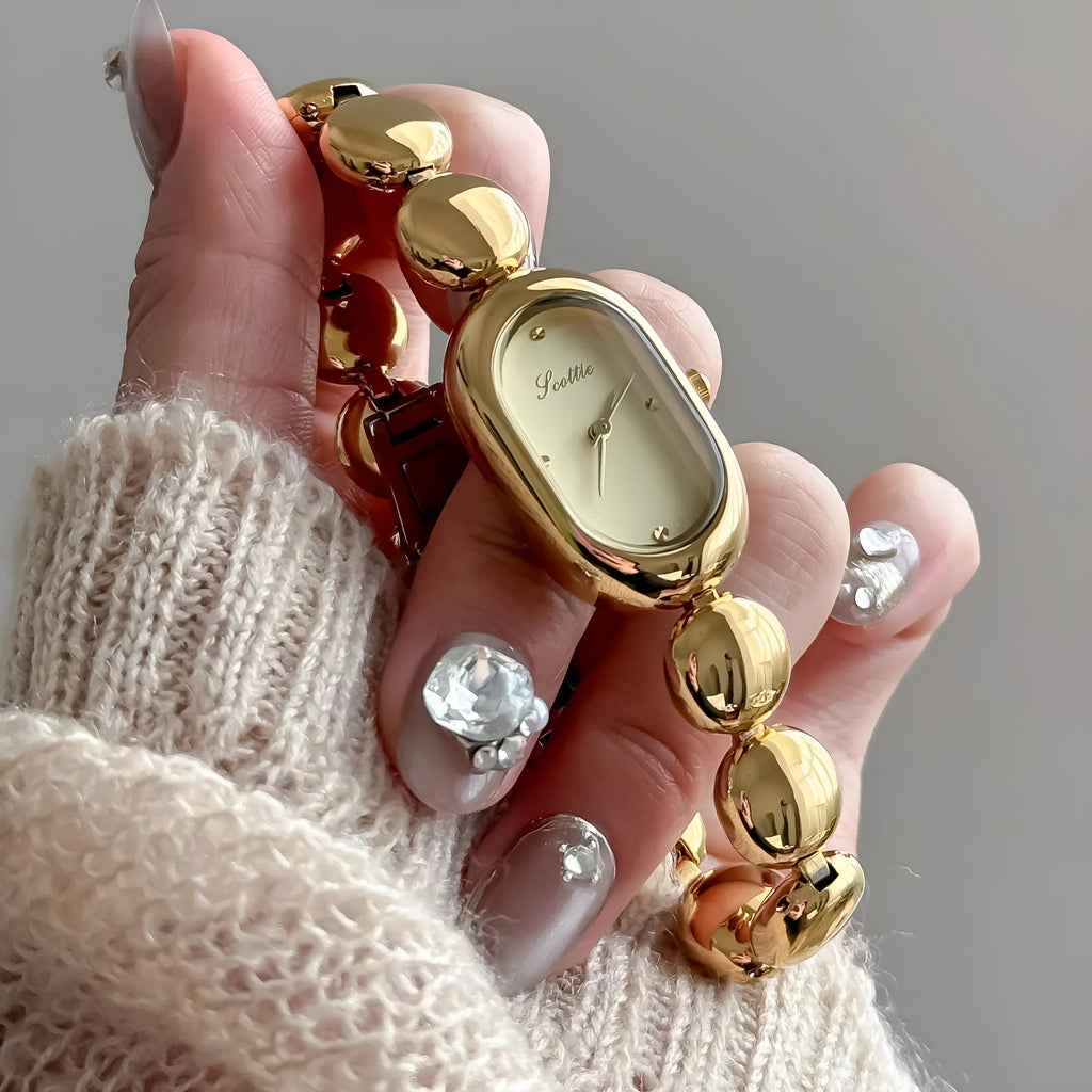 Women's oval gold-toned watch with slim 9mm stainless steel case