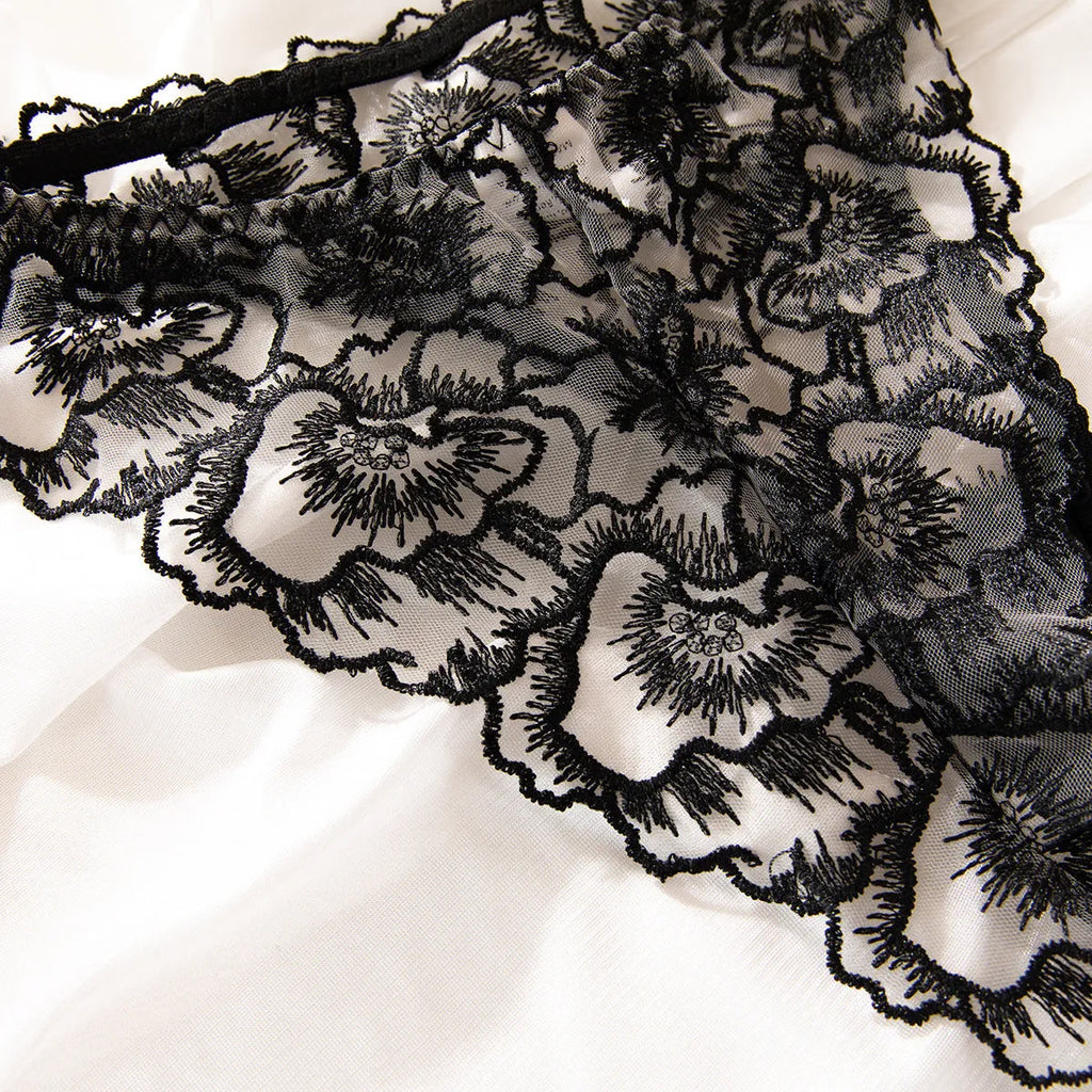Black women's embroidered lace bikini set with a thin transparent fabric and a silver steel ring detail.