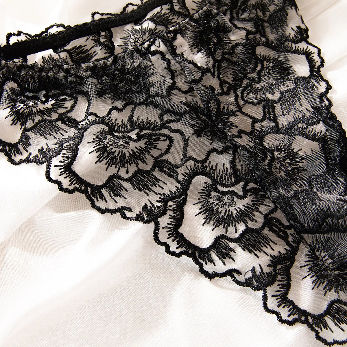 Black women's embroidered lace bikini set with a thin transparent fabric and a silver steel ring detail.