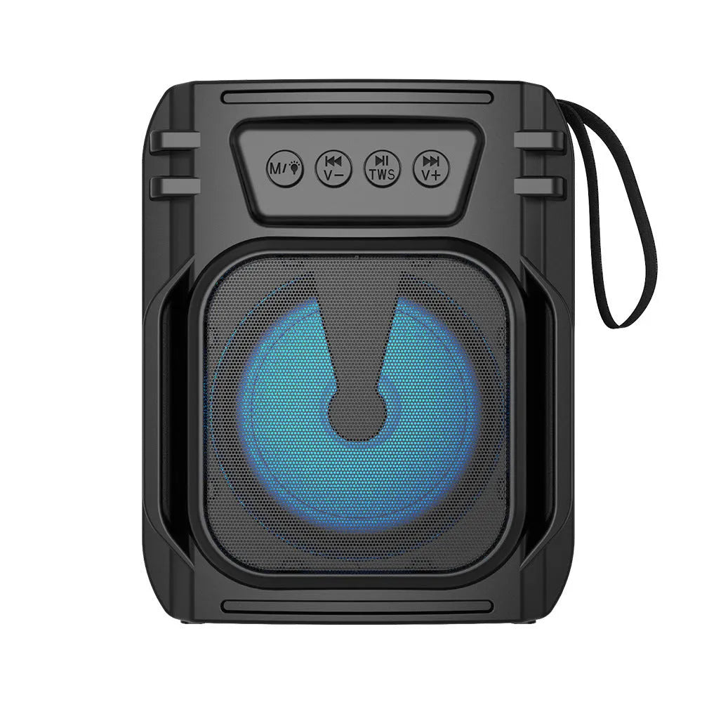 Compact portable Bluetooth speaker with USB charging cable on a desk.