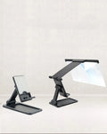 Black folding mobile phone screen magnifier and detachable holder on a desktop.