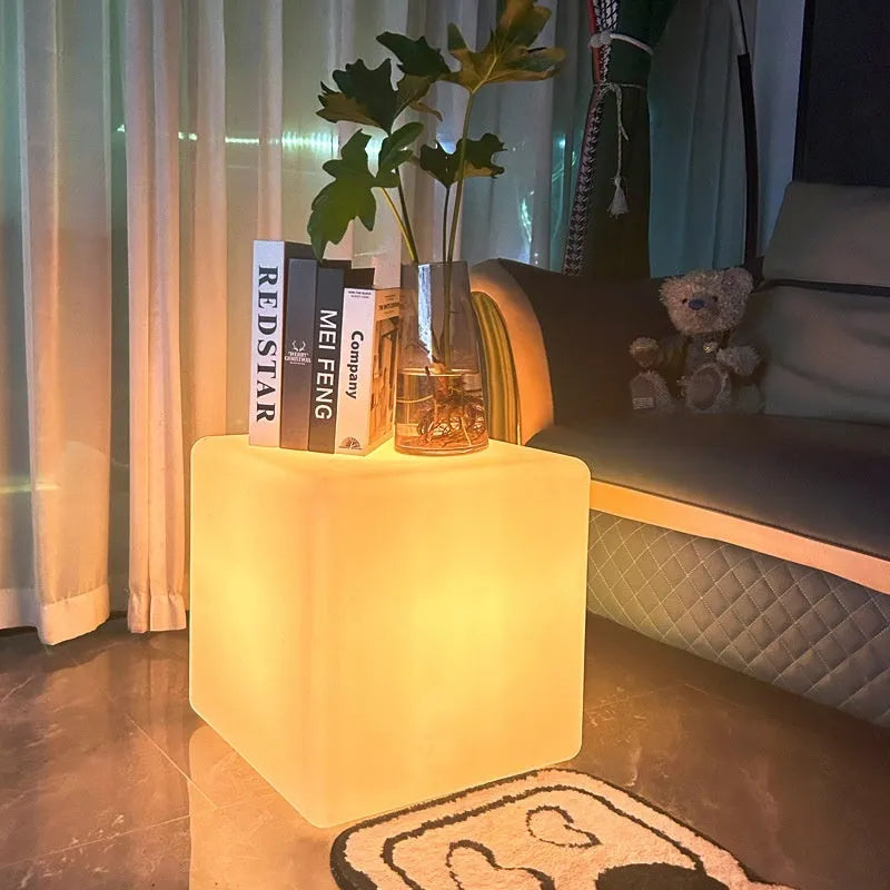 A modern white LED cube light stool sitting outdoors on a patio.