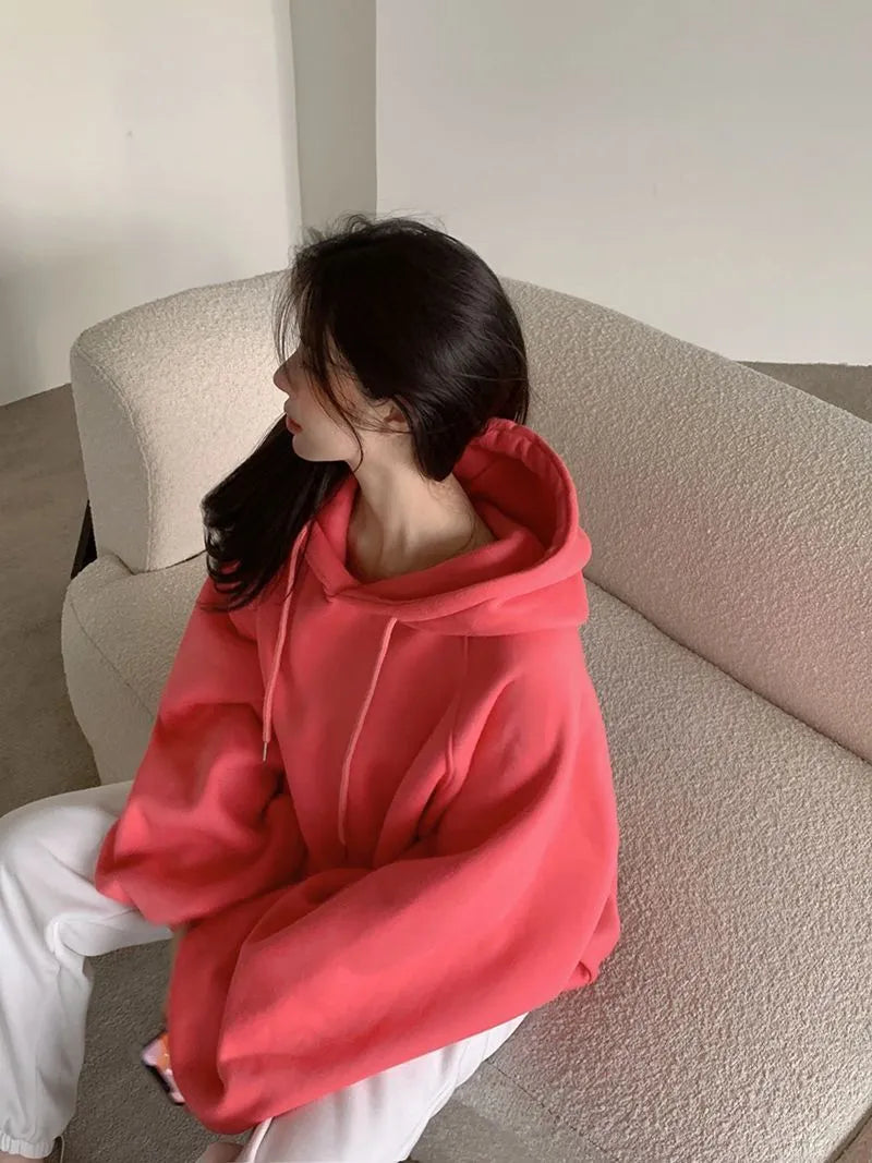 Watermelon red women's loose mulberry silk hooded sweater on a hanger.