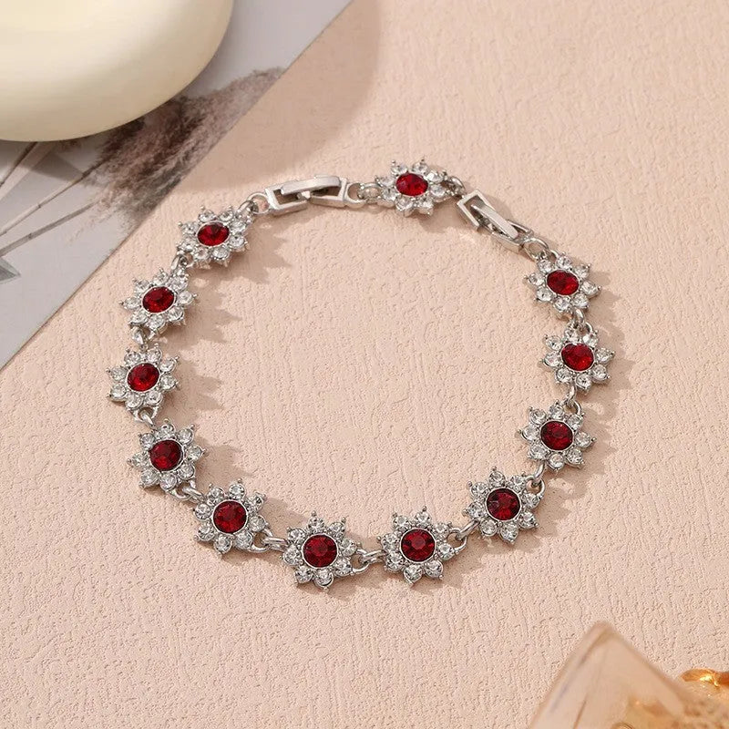 Electroplated zinc alloy bracelet with flower-shaped design and coloured gem elements in metallic finish