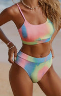 Women's blue and orange tie-dye pleated split bikini on a mannequin, showing gradient pattern and briefs style.