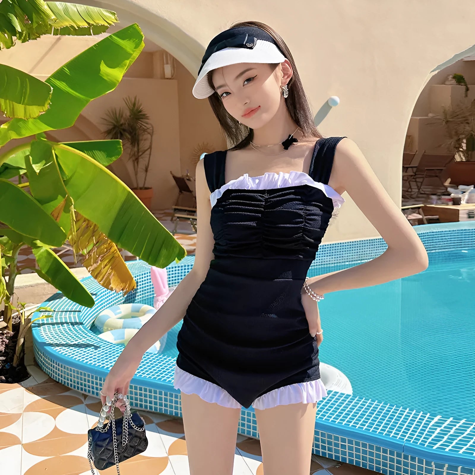 Women's black one-piece swimsuit with suspender straps, polyester fabric, solid colour design