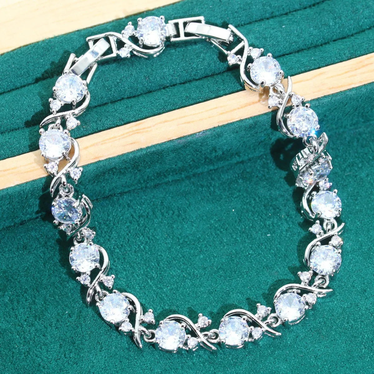 Bridal zircon four-piece jewellery set showing necklace, bracelet, earrings and ring with water wave chain design