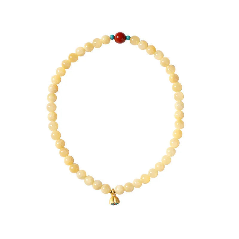 Yellow jade double ring bracelet with topaz lotus seedpod design on white background