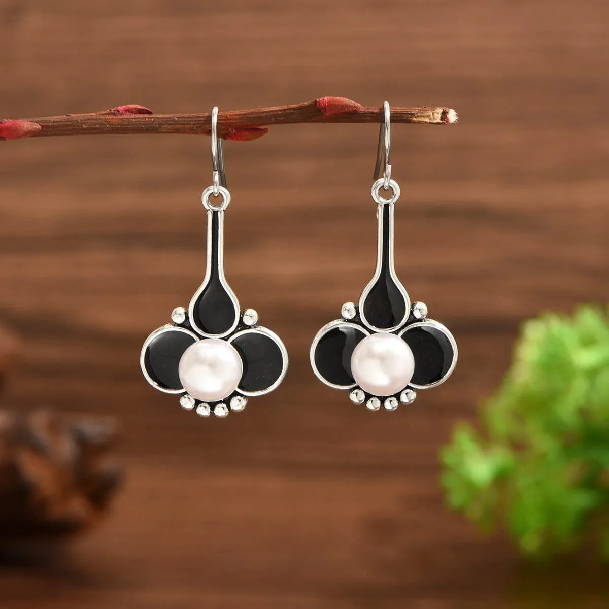 A pair of silver-coloured retro-style fashion earrings for women.