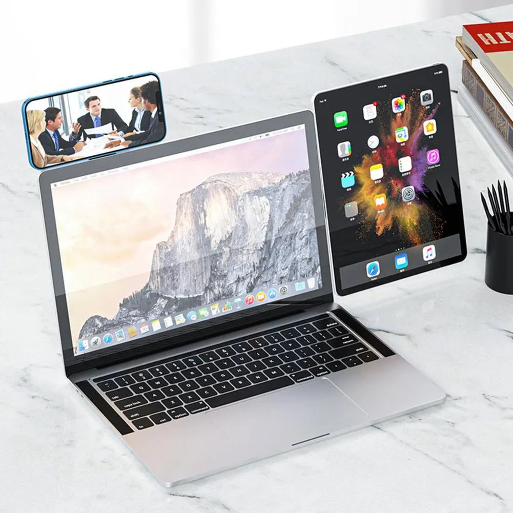 Black aluminium laptop phone holder mounted beside laptop screen showing dual-screen setup