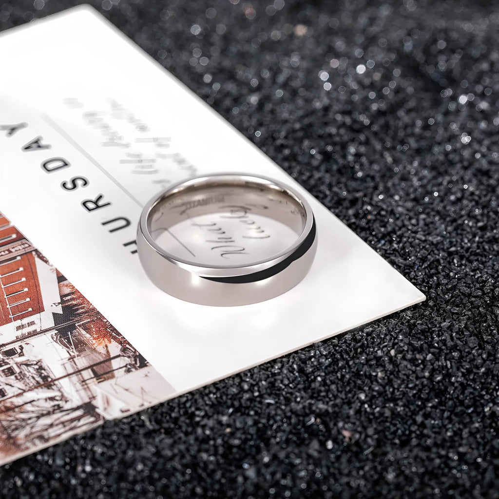 Simple silver titanium steel ring shown in various widths on a size chart.