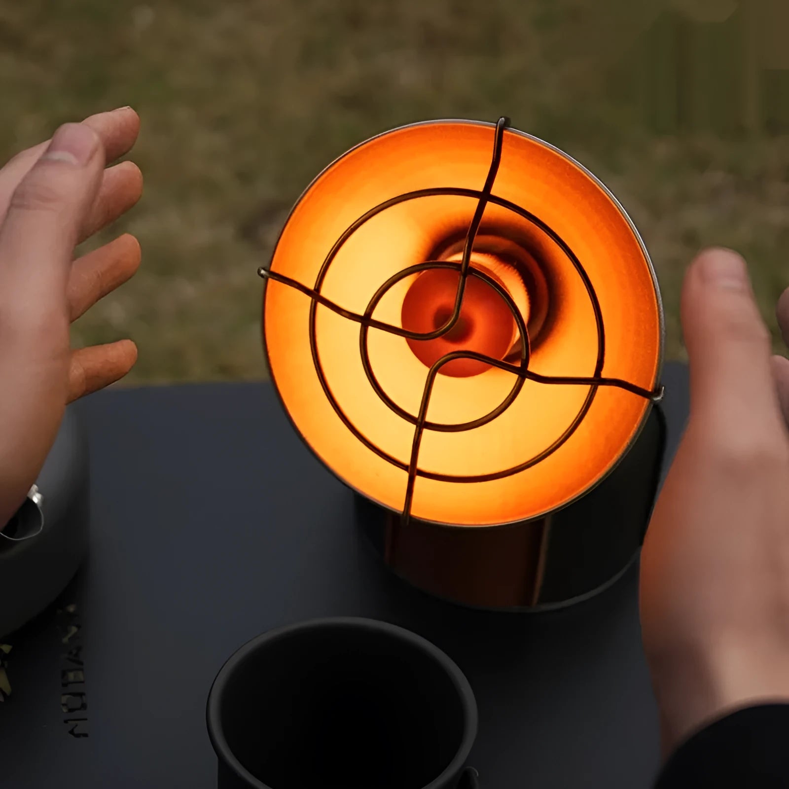 Black and orange portable outdoor gas heating stove with piezo ignition on a table
