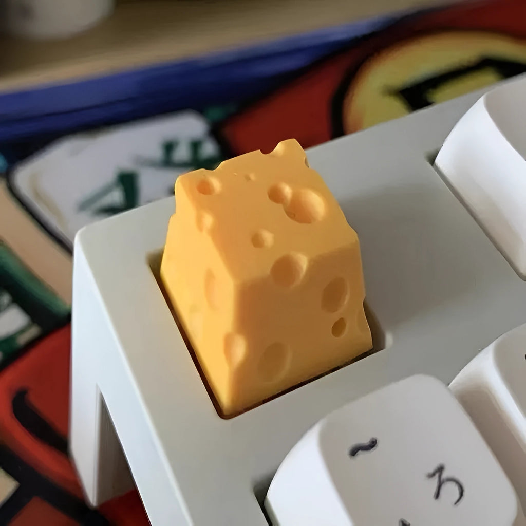Yellow resin artisan keycap with a three-dimensional cheese design for mechanical keyboards.