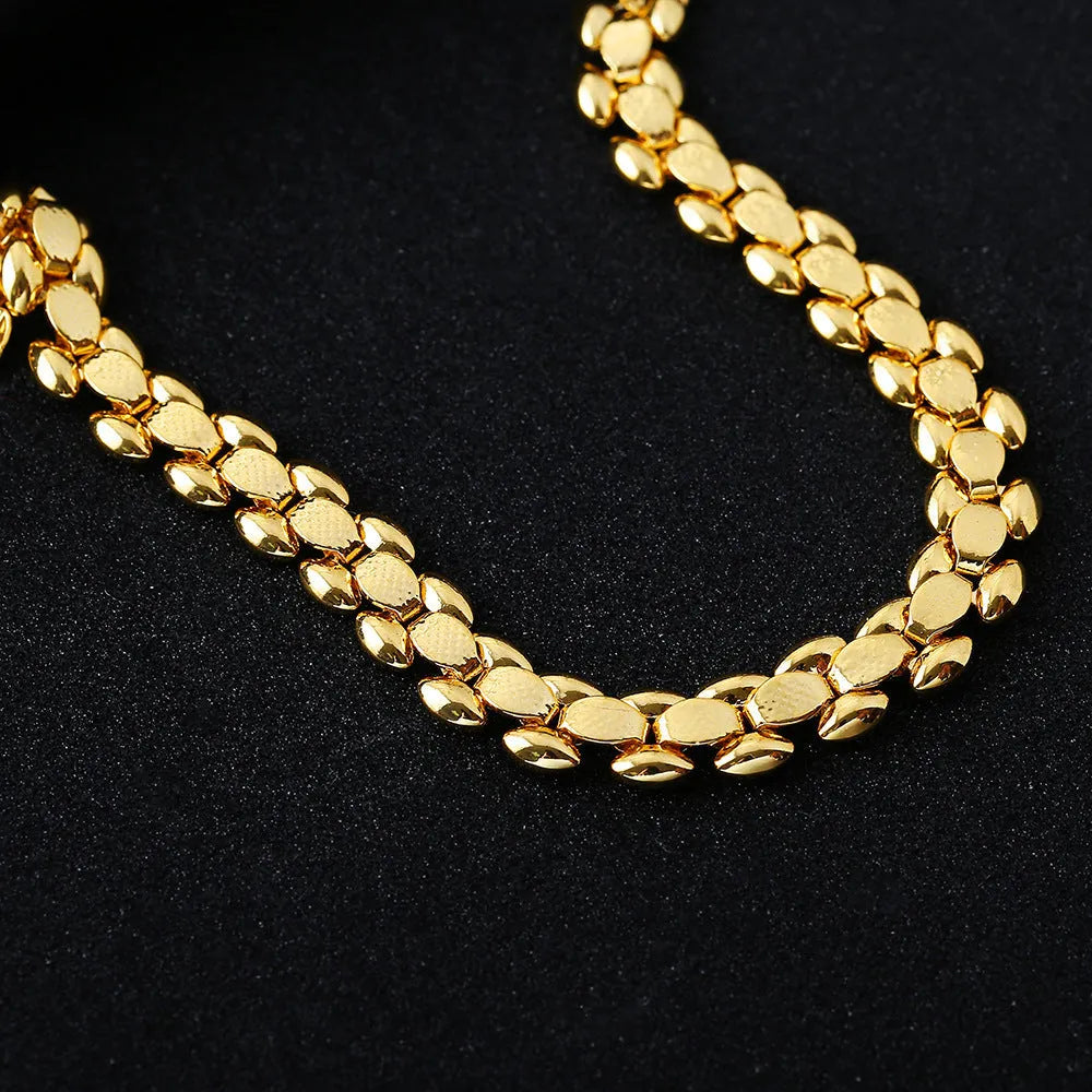 L254 Gold iron bracelet laid flat on a surface, showing its metallic finish and simple design.